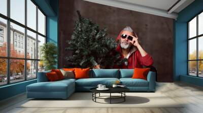 Fashionable modern Santa old man in red fashion hoodie and sunglasses Merry Christmas Wall mural