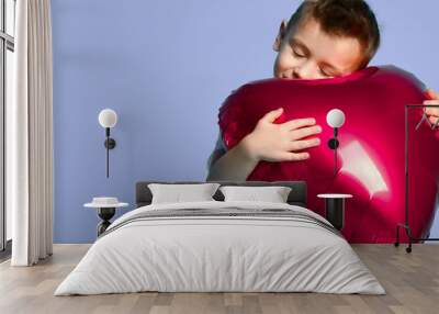 Little boy love hold big red heart balloon to celebrate valentines day on purple  Wall mural