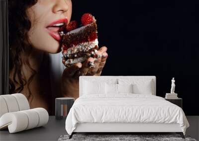 Pretty young woman eating birthday chocolate piece of cake with raspberry fruits celebrating  Wall mural