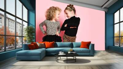 Two cool kids girls best friends sisters in leopard print clothes pants and sweater are looking at each other and walks Wall mural