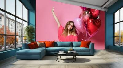 Valentine Beauty girl hold red and pink air balloons laughing on pink background celebrating Valentines Day Wall mural