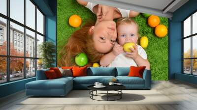 Young mother woman and daughter child baby kid girl lying down Wall mural