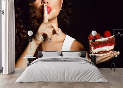 Young woman chef cook holding sweet piece cake with strawberry blueberry and cream show quiet shhh sign Wall mural