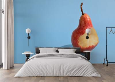 ripe yellow-red pear with a bite off. a stalk sticks out from above. the pear casts a harsh shadow Wall mural