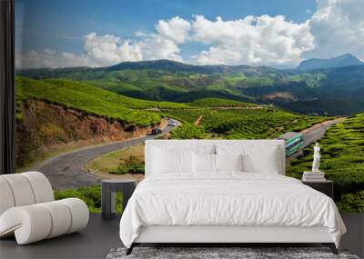 Passenger bus on road in tea plantations, India Wall mural