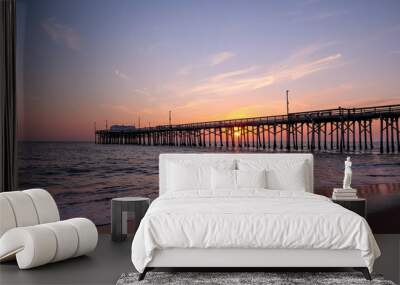 Scenic sunset over the Pacific ocean. A setting sun behind the long pier, Irvine, Orange County, California Wall mural