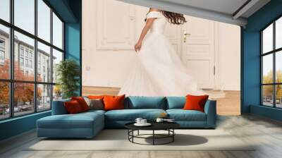 Young beauiful happy bride wearing white wedding dress and posing in bright empty interior Wall mural