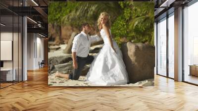 Beautiful young couple kissing on sunset, standing barefoot on b Wall mural