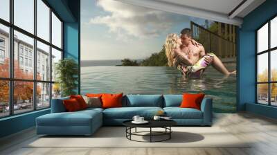 Young, sexy and attractive couple coming into swimming pool in s Wall mural