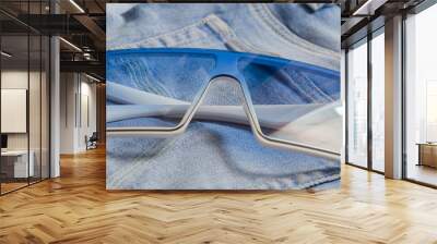 square plastic glasses lie on jeans Wall mural