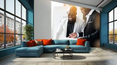 The black attorney shows documents to the Director in a white jacket while in the evening in the office Wall mural