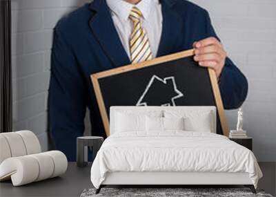 Man in a suit with a black board in his hands on a white backgro Wall mural