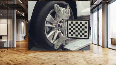 Wheel alignment equipment on a car wheel in a repair station Wall mural