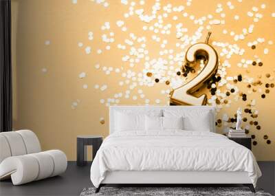 2 years celebration festive background made with golden candle in the form of number Two lying on sparkles. Universal holiday banner with copy space. Wall mural