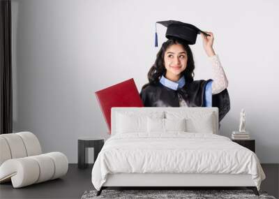 Beautiful indian woman university graduate wearing academic regalia with red diploma mockup isolated on white background. Wall mural