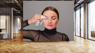 Beautiful woman removing makeup from her face. Beauty concept Wall mural