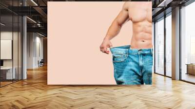 Man wearing big jeans after diet on pastel background Wall mural