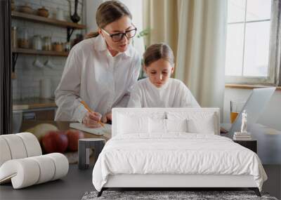 Mother supporting daughter with homework in kitchen Wall mural