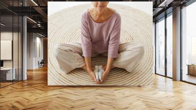 Relaxed mature woman practicing yoga at home Wall mural