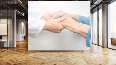 Helping and care for the elderly concept.Young nurse hands holding an old hands of senior woman. Wall mural