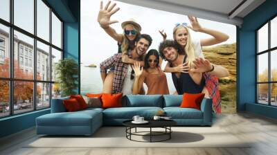 Shot of a group of young friends enjoying a day at the beach Wall mural