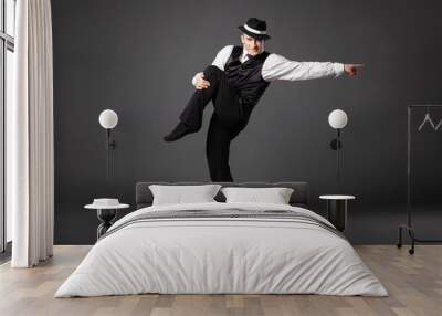 Confident young man dancing in gangster style suite. Wall mural