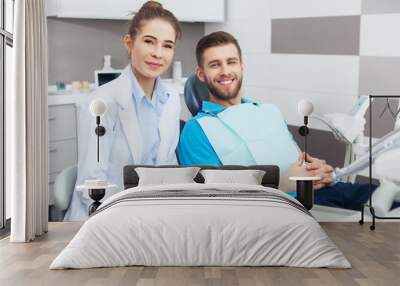 portrait of a female dentist and young man in a dentist office. Wall mural