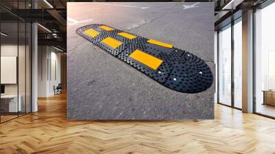 Speed bump on asphalt road. Speed Limit Tool in a city. Wall mural