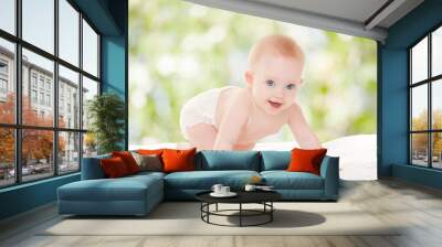 Cute baby with beautiful blue eyes on the white bed Wall mural