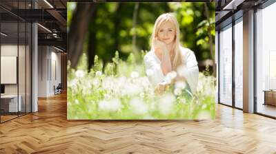 Cute woman rest in the park with dandelions Wall mural