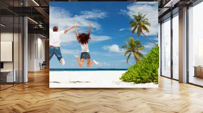 Happy couple jumping on the tropical beach Wall mural