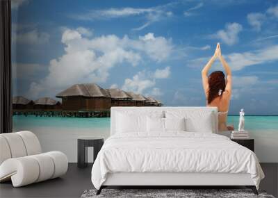 woman doing yoga exercises on the beach Wall mural