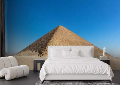 Old big pyramid with the blue cloudless sky on the background. Wall mural