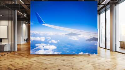 airplane wing with blue sky and white clouds Wall mural