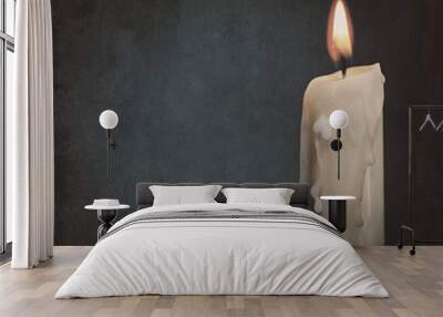 Burning candle over dark backgrounds. Abstract grungy still life Wall mural