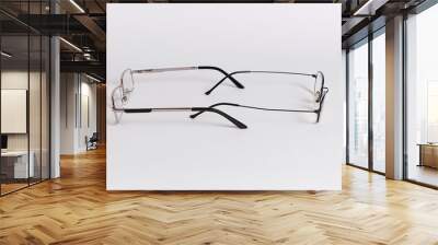 Two pairs of glasses are located against each other  Glasses close-up on a white background Wall mural