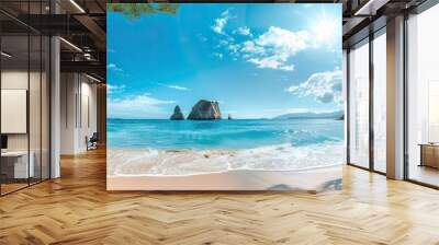 Beach, very clear water, through which you can see the bottom of the sea. Small islands can be seen in the panorama, in the background of which is the clear sky and the bright sun. Wall mural