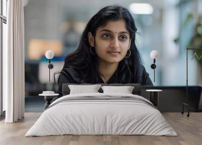 Portrait of an indian woman sitting in an office using a laptop Wall mural