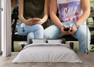 young couple typing sms, while sitting on a bench Wall mural