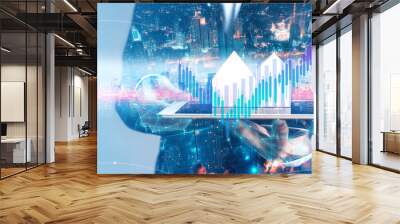 Businessman holding tablet with city hologram show a financial stock market increase profit graph in cyber punk theme Wall mural