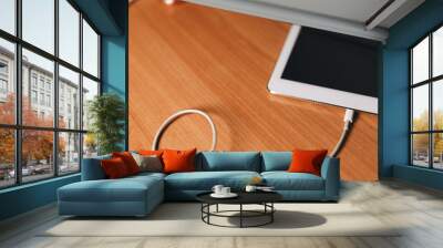 Charge smart phone on wooden work table. Wall mural