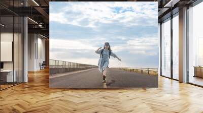 Happy smile young woman traveller with backpack walking on road travel on summer holiday Wall mural