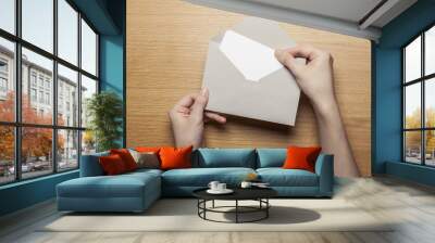 woman hand hold a envelope and letter on the wood table. Wall mural