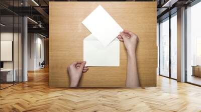 woman hand hold a white envelope on the wood table(background) Wall mural