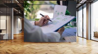 Analyzing green building performance metrics during business meeting. data analysis, green building, business meeting, sustainability, performance metrics, charts, graphs, real estate, eco-friendly. Wall mural