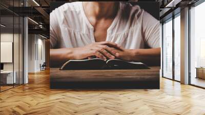 Close up of christian woman hand on holy bible are pray and worship for thank god in church with black background, concept for faith, spirituality and religion Wall mural