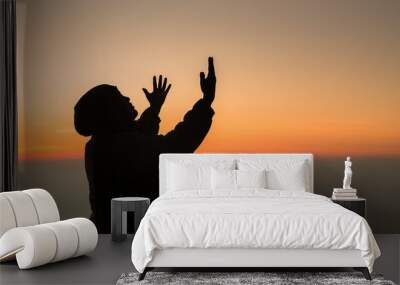 Concept Christian person worship or pray to God. Christian man silhouette with love, faith, devotion to God with sunrise sky background.Male worship God for peace, victory, success with hope. religion Wall mural