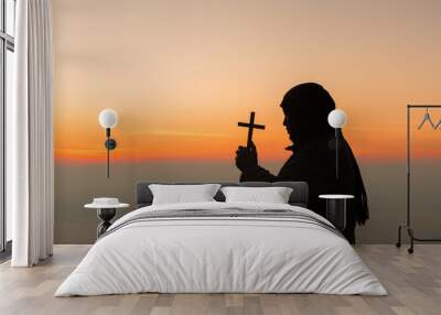 Concept Christian person worship or pray to God. Christian man silhouette with love, faith, devotion to God with sunrise sky background.Male worship God for peace, victory, success with hope. religion Wall mural