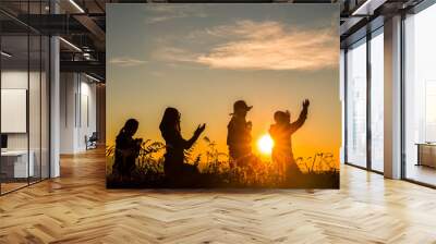 four girl bowed and prayed at sunset in the mountains Wall mural