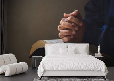 Hands folded in prayer on a Holy Bible in church concept for faith Wall mural